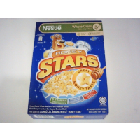 Коробка хлопьев для завтрака Nestlé Honey Stars, на которой изображен известный мультяшный медведь-талисман на синем фоне.