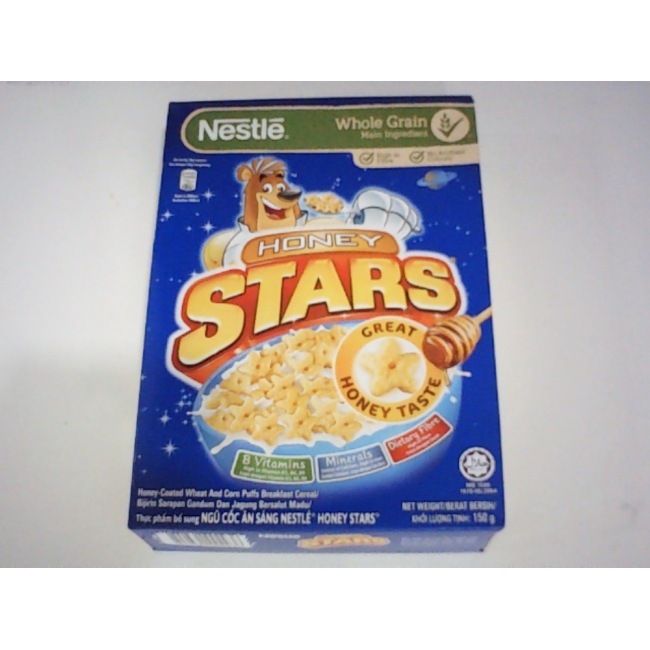 Коробка хлопьев для завтрака Nestlé Honey Stars, на которой изображен известный мультяшный медведь-талисман на синем фоне.
