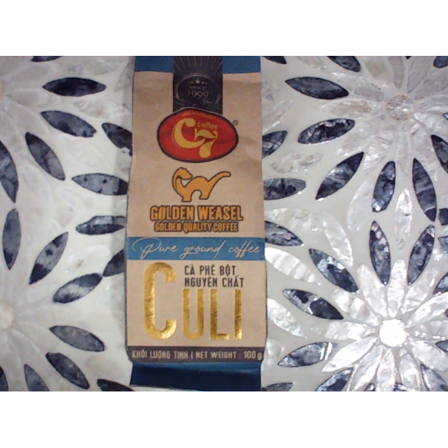 Молотый кофе Golden Weasel C7 Culi от Huca Food — это особый вьетнамский кофе, полученный методом экстракции из зерен циветты (кули), в виде плотных зерен, упакованных в 100-граммовый пакет бежево-синего цвета.